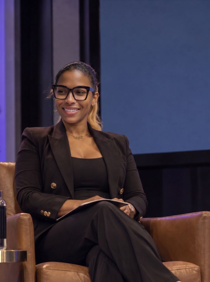 Dr. Gee seated in a leather chair on a panel