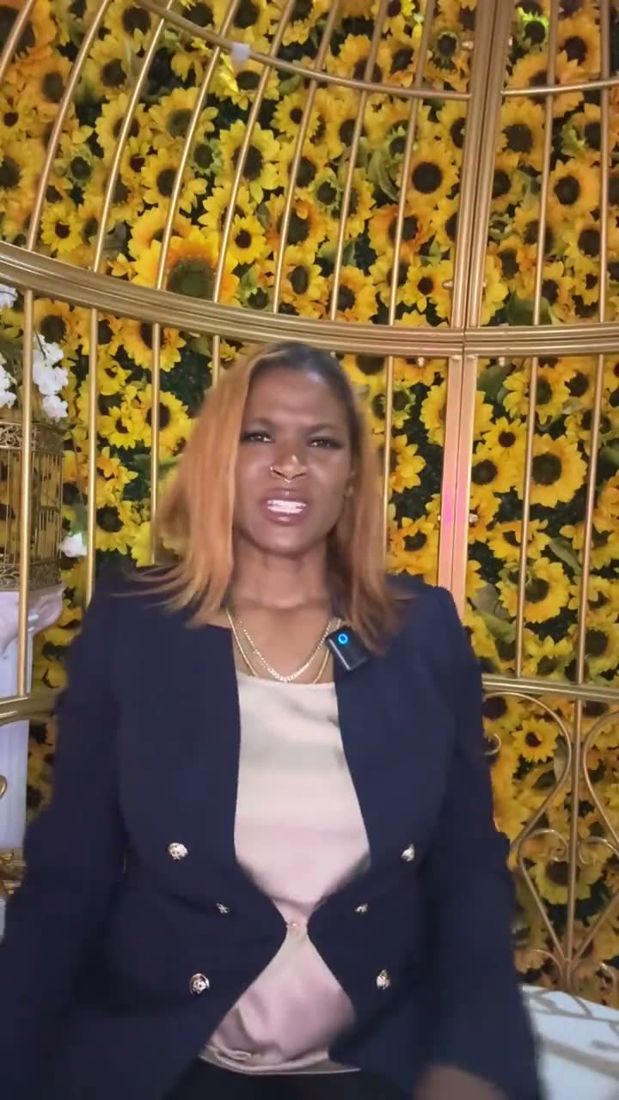 Dr. Gee in a navy blazer in front of a wall of sunflowers