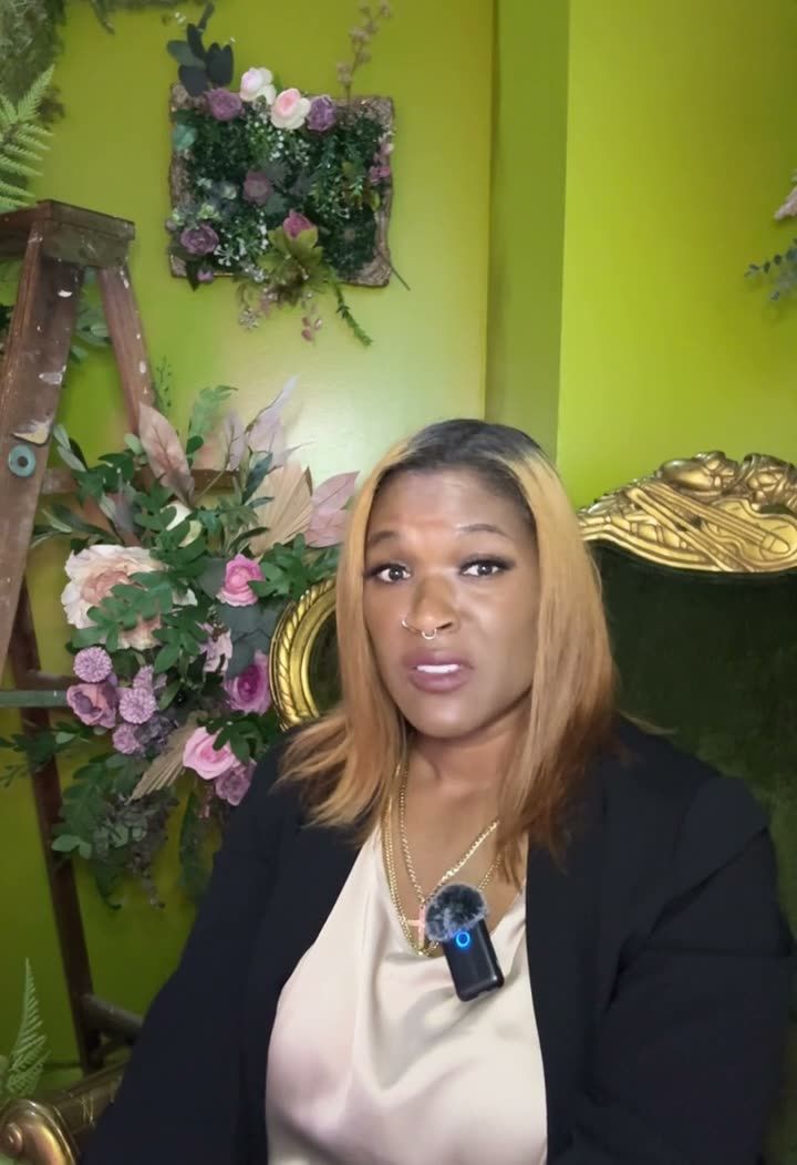 Dr. Gee speaking to camera in front of a green floral wall
